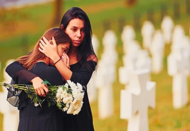 Two girls comforting each other on a funeral.