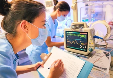 A nurse monitoring a premature newborn child.