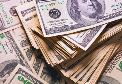 Stack of one hundred dollars notes on dollars background.