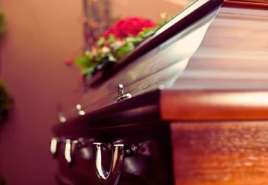Wooden casket with red flowers on. what happens to a personal injury lawsuit when the defendant dies