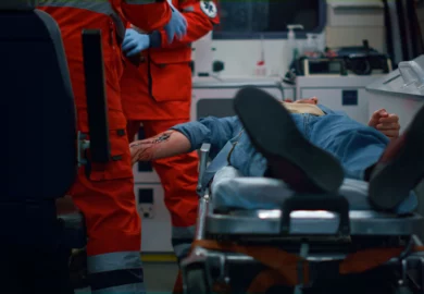 Injured driver being treated in an ambulance by two paramedics.