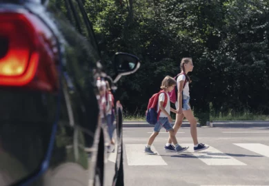 Two children walking on a pedestrian lane.