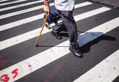 An elderly man walking on a pedestrian lane.