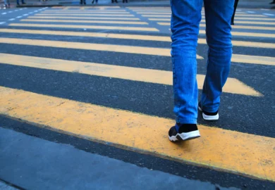 A man crossing a pedestrian lane.