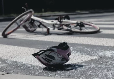 A helmet and a bicycle lying on the ground.