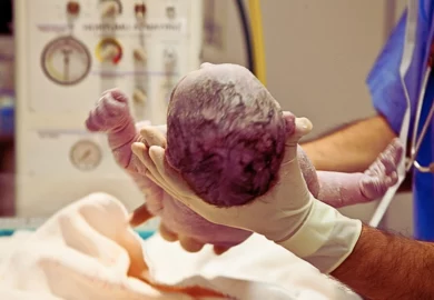 Newborn baby boy lying on a table just after cleaning and being assessed by a nurse. Can You Sue a Doctor for a Birth Injury