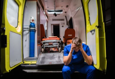 Distressed paramedics sitting on an ambulance.