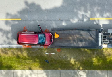 Red car being towed after a collision.