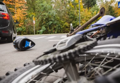 Motorcycle lying on the street after being hit by a car.
