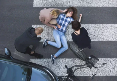 severely injured woman with her bike lying on the road after an accident.