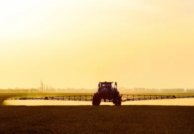 Tractor in the field with sun setting.
